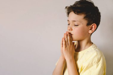 Elleri bağlı bir çocuk, dua ediyor ya da meditasyon yapıyor. Hıristiyanlık, din ve inanç kavramı.