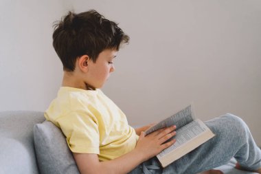 Bir çocuk kutsal kitabı okuyor ve dua ediyor ya da meditasyon yapıyor. Hıristiyanlık, din ve inanç kavramı.