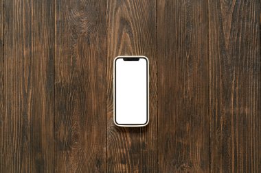 Ahşap arka planda beyaz ekranlı telefon. Telefondaki boş ekran.