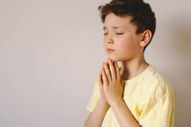 Elleri bağlı bir çocuk, dua ediyor ya da meditasyon yapıyor. Hıristiyanlık, din ve inanç kavramı.