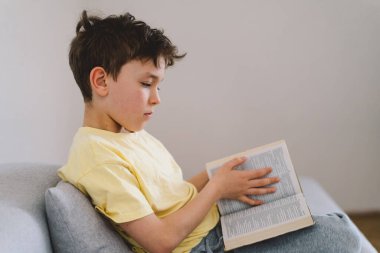 Bir çocuk kutsal kitabı okuyor ve dua ediyor ya da meditasyon yapıyor. Hıristiyanlık, din ve inanç kavramı.