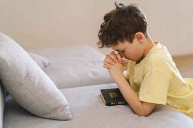 Elleri bağlı bir çocuk, dua ediyor ya da meditasyon yapıyor. Hıristiyanlık, din ve inanç kavramı.