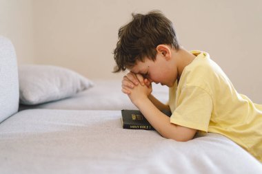 Elleri bağlı bir çocuk, dua ediyor ya da meditasyon yapıyor. Hıristiyanlık, din ve inanç kavramı.