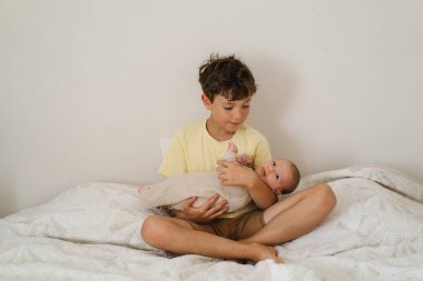 Two little boys brothers enjoying playing in cozy bright bedroom, smiling and playing. Happy childhood. Children portraits.