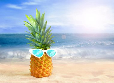 Tropik plaj arka planında güneş gözlüklü ananas. Yaz konsepti.