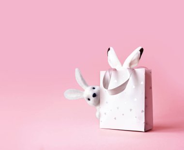 Easter bunny ears in a paper bag. Pink background. Space for text. Happy easter