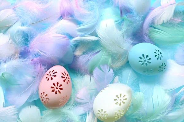 Easter background with feathers and eggs on blue background. Flat lay. Happy easter day card.