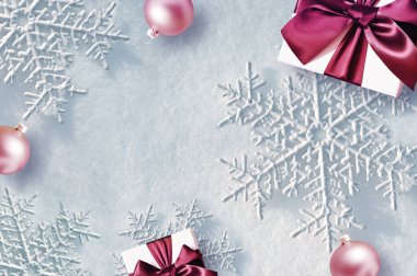 Noel kompozisyonu. Hediye, beyaz karlı arka planda toplar. Noel, kış, yeni yıl konsepti. Düz konum, üst görünüm, kopyalama alanı