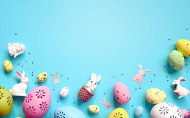 Mavi arka planda Paskalya kutlaması için çiçeklerle süslü renkli yumurta koleksiyonu. Tatil kavramı.