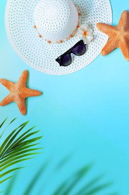 Yaz tasarımı konsepti. Mavi arka planda deniz yıldızı, şapka, güneş gözlüğü ve palmiye yapraklarıyla üst manzara.