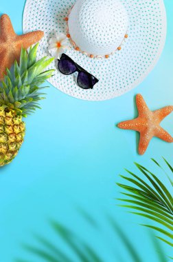 Yaz tasarımı konsepti. Mavi arka planda deniz yıldızı, ananas, şapka, güneş gözlüğü ve palmiye yapraklarıyla üst manzara.
