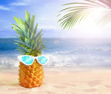 Güneş gözlüklü ananas ve tropik plaj arka planında avuç içi. Yaz konsepti.
