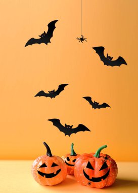 Cadılar Bayramı süsleri, balkabağı, örümcek ve turuncu arka planda yarasa. Cadılar Bayramı partisi konsepti