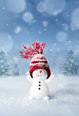 Kışın kar üzerinde şapkalı küçük bir kardan adam. Komik bir kardan adamla şenlik geçmişi. Noel kartı, kopyalama alanı.
