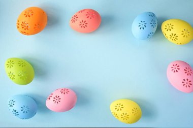 Mavi arka planda Paskalya kutlaması için renkli yumurta koleksiyonu. Tatil kavramı.