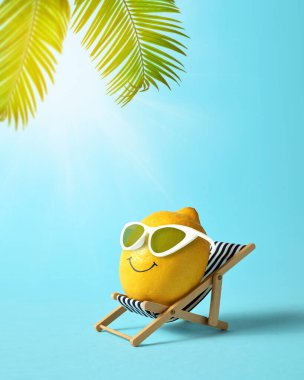 Güneş gözlüklü limon sahildeki şezlongda dinleniyor. Yaz tropik asgari mizah kavramı.