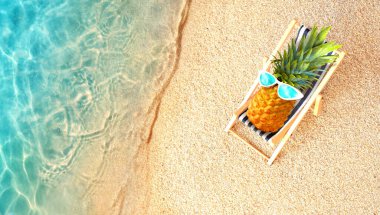 Ananas, turkuaz denize karşı kumsalda güneşli sandalyede uzanıyor. Rahatlatıcı. Tropik yaz tatili konsepti.