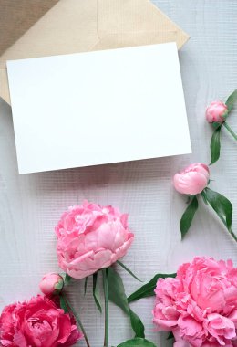 Beyaz arka planda zarfı olan şakayık ve kağıt kartlı güzel kompozisyon.