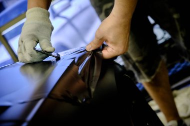 Tamircide araba tekerleğini temizleyen bir tamirci. Araç bakımı devam ediyor. 