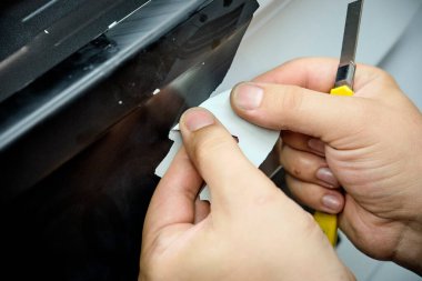 Tamircide araba tekerleğini temizleyen bir tamirci. Araç bakımı devam ediyor. 