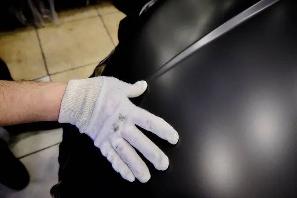 Tamircide araba tekerleğini temizleyen bir tamirci. Araç bakımı devam ediyor. 