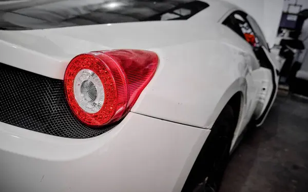 Tamircide araba tekerleğini temizleyen bir tamirci. Araç bakımı devam ediyor. 