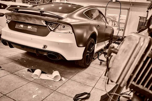 Tamircide araba tekerleğini temizleyen bir tamirci. Araç bakımı devam ediyor. 