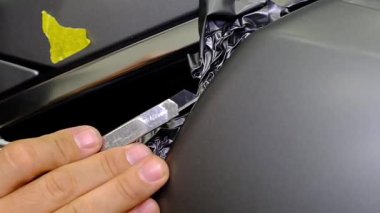 Tamirci, oto tamir atölyesinde bir araba tekerleğini yavaş çekimde temizliyor. Araç bakımı devam ediyor. 