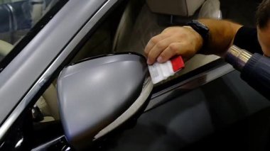 Tamirci, oto tamir atölyesinde bir araba tekerleğini yavaş çekimde temizliyor. Araç bakımı devam ediyor. 