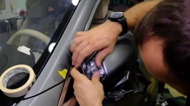 Tamirci, oto tamir atölyesinde bir araba tekerleğini yavaş çekimde temizliyor. Araç bakımı devam ediyor. 