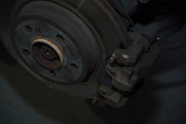 Bir araba servisi atölyesinde özel araba döşemesi için siyah deri ya da sentetik malzeme kesip hazırlamak. Elleri yakın plan işaretleme, makasla kesme, ve malzeme parçalarını şekillendirme.