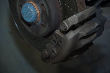 Bir araba servisi atölyesinde özel araba döşemesi için siyah deri ya da sentetik malzeme kesip hazırlamak. Elleri yakın plan işaretleme, makasla kesme, ve malzeme parçalarını şekillendirme.