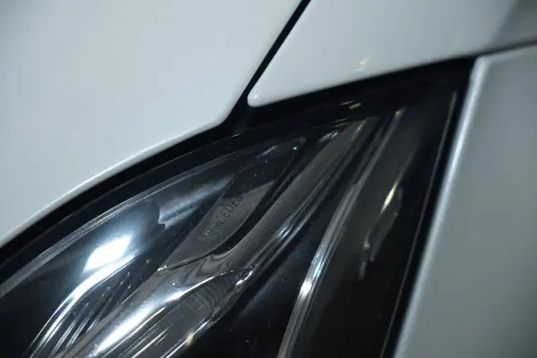 Bir araba servisi atölyesinde özel araba döşemesi için siyah deri ya da sentetik malzeme kesip hazırlamak. Elleri yakın plan işaretleme, makasla kesme, ve malzeme parçalarını şekillendirme.