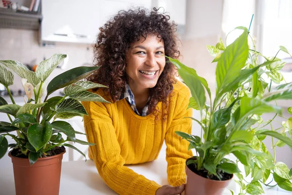 Black woman successful green thumb taking care of home plants