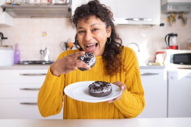 Black woman breaking diet and eating sweet donuts