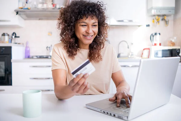 Happy black woman using credit card and home shopping online