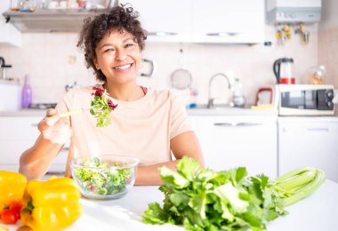 Healthy eating concept. Black woman eating vegetables salad portrait
