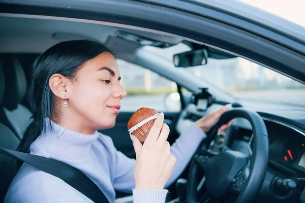 Una Mujer Está Conduciendo Coche Comiendo Comida — Foto de Stock