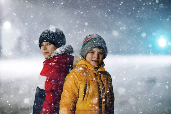 下雪天清晨 两个小学的小男孩步行去学校 快乐的孩子们玩的开心 玩的是初雪 姐姐们的朋友们穿着五彩缤纷的冬衣 — 图库照片