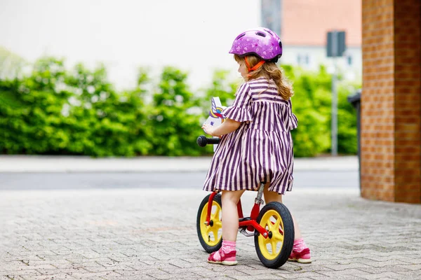 夏天的一天 一个蹒跚学步的小女孩骑着平衡自行车跑步 快乐的孩子驾驶 骑自行车 户外活动 — 图库照片
