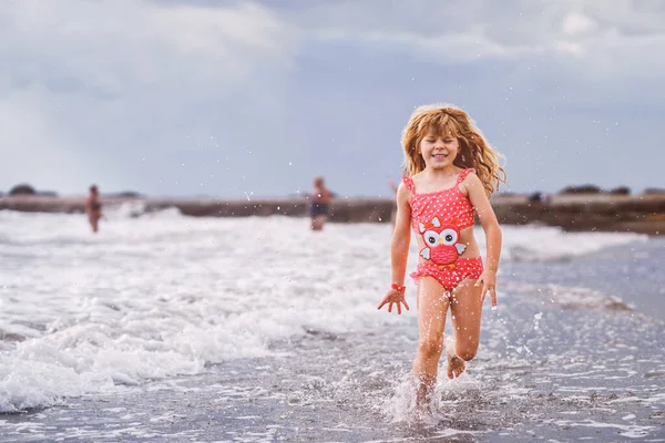 幸せな子供 小さな就学前の女の子は エキゾチックな熱帯のビーチで夏休み中に波に飛び乗っています 海沿岸での家族旅行 — ストック写真