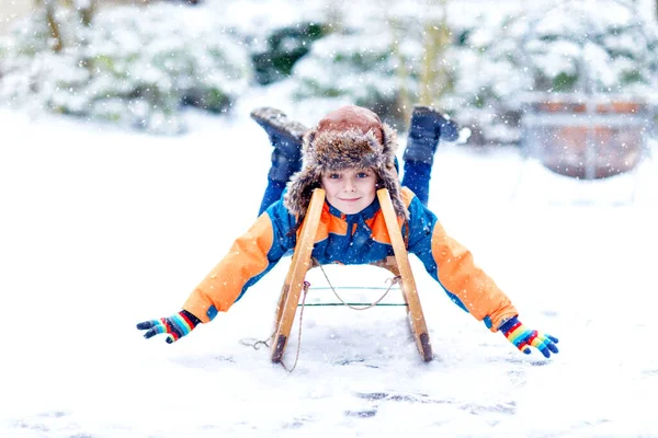 小男孩喜欢在降雪时乘坐雪橇 开开心心的学龄前儿童骑着老式雪橇 孩子们在外面与雪玩耍 冬季家庭圣诞假期的积极乐趣 — 图库照片