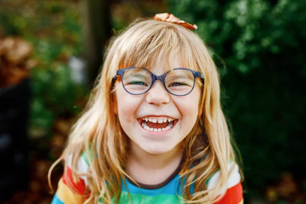 十月温暖的一天 在秋天的公园里 用橡木和枫叶给学龄前小女孩画像 有很多叶子的孩子秋天的家庭户外乐趣 小孩在笑健康 戴眼镜的孩子 — 图库照片