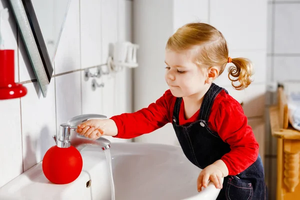 可爱的小女孩在浴室里用肥皂和水洗手 可爱的孩子学习清洁身体的部分 早上的卫生习惯 在家里或托儿所里快乐健康的孩子 — 图库照片