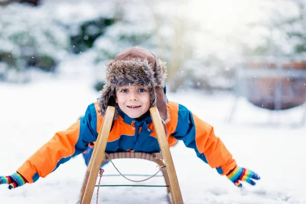 小さな男の子は雪の中でそりに乗る ヴィンテージのそりに乗って幸せな就学前の子供 子供は雪で屋外で遊ぶ 冬の家族のクリスマス休暇のための積極的な楽しみ — ストック写真