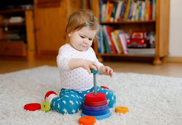 사랑스럽고 귀여운 소녀가 교육용 장난감을 가지고 집이나 보육원에서 스택피라 장난감을 — 스톡 사진