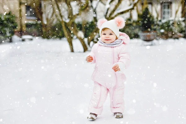 快乐的小女孩在冬天的雪地里迈出了第一步 可爱的幼儿学习走路 孩子们在寒冷的雪天玩得很开心 穿着保暖的婴儿粉红衣服 头戴水泡帽 — 图库照片