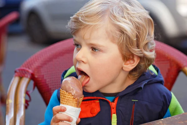 かわいいかわいい男の子が屋外カフェでアイスクリームを食べています 晴れた日の幸せな子供 健康的な幼児はゼラチンレストランで甘いデザート — ストック写真