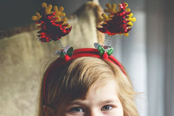一个带着圣诞树头巾的学龄前小女孩的画像 快乐微笑的孩子 — 图库照片