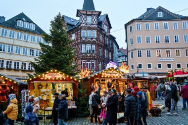 MARBURG, GERMANY - 4 Aralık 2022: Noel dekorasyonlu eski pazar yeri, mağazalı eski evler, restoranlar ve Noel pazarının ziyaretçileri. Geleneksel Noel pazarı.